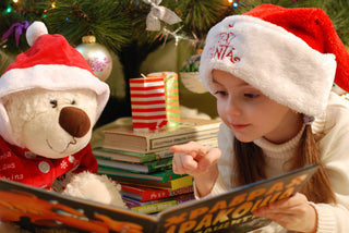 child in christmas hat with teddy bear